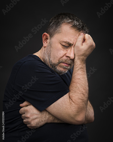 Photo: Headache. Man with face closed by hand Headache. Man with face closed by hand