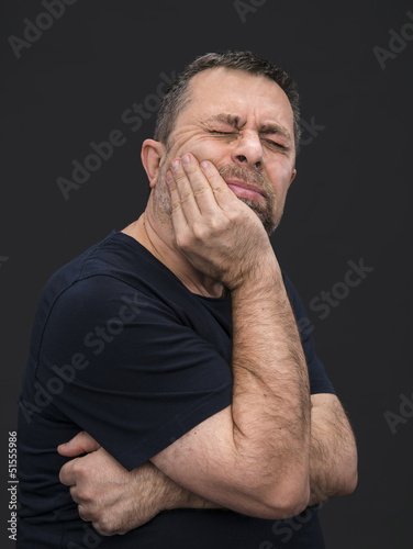 Photo: Toothache. Man with face closed by hand Toothache. Man with face closed by hand