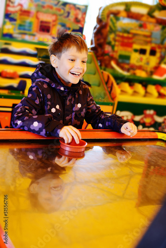 Photo: boy playing air hockey game boy playing air hockey game