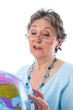 Photo: Seniorin geht auf Reisen - ältere Frau isoliert mit Globus Seniorin geht auf Reisen - ältere Frau isoliert mit Globus