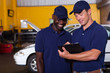 happy auto mechanics going through checklist