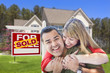 Couple in Front of Sold Real Estate Sign and House