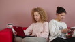 Two female friends sitting with tablet and laptop computer