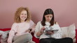 Two female friends  with tablet computer watching tv