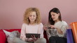 Two young girls buying on line with credit card, tracking shot