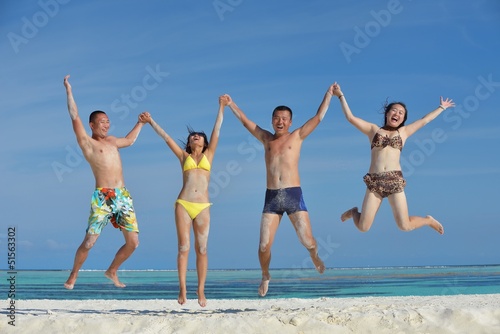 Photo: group of happy young people have fun on bach group of happy young people have fun on bach