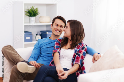 Photo: Loving couple sitting in living room Loving couple sitting in living room
