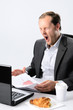 Yawning man in suit with half eaten breakfast and coffee