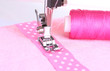 Closeup of sewing machine working part with  pink  cloth