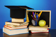 Books and magister cap against school board