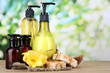 Liquid and hand-made soaps on wooden table, on green background