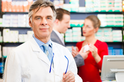 Photo: Pharmacist with customers in pharmacy Pharmacist with customers in pharmacy