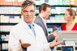 Photo: Pharmacist with customers in pharmacy Pharmacist with customers in pharmacy