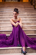 woman in a long dress is sitting on the stairs