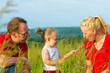 Kid in the meadow blowing dandelion seed