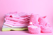 Pile of baby clothes on pink background