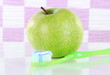 Apple with a toothbrush on shelf in bathroom