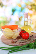Peeled vegetables in bowl on bright background
