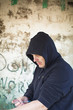 Drug addict man with syringe in hands on a wall background