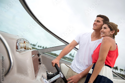 Photo: Couple driving a boat Couple driving a boat