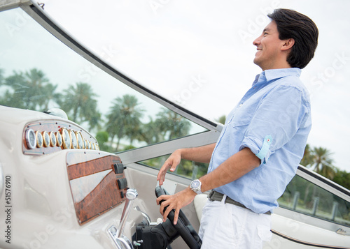 Photo: Man behind the wheel of a boat Man behind the wheel of a boat