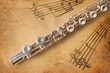 Silver flute on an ancient musical background