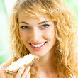 Photo: Portrait of young happy woman eating crispbread Portrait of young happy woman eating crispbread
