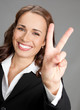 Businesswoman showing two fingers or victory gesture
