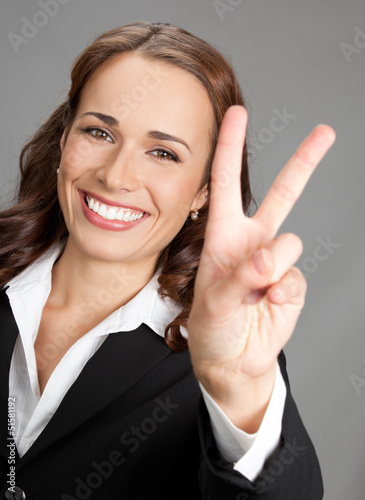 Photo: Businesswoman showing two fingers or victory gesture Businesswoman showing two fingers or victory gesture