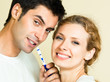 Cheerful young couple cleaning teeth together