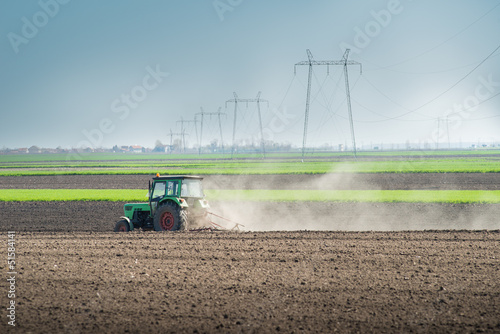 Photo: Tractor plowing the fields in spring Tractor plowing the fields in spring