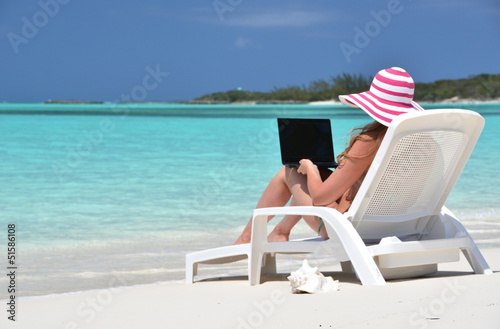 Photo: Girl with a laptop on the tropical beach. Exuma, Bahamas Girl with a laptop on the tropical beach. Exuma, Bahamas