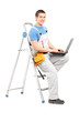 Full length portrait of a handy man with a laptop sitting on a l