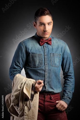 Photo: Attractive male model holding coat and posing Attractive male model holding coat and posing