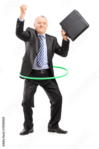 Photo: Full length portrait of a matue businessman dancing with a hula Full length portrait of a matue businessman dancing with a hula