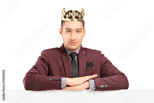 Photo: Handsome prince posing on a panel with a diamond crown Handsome prince posing on a panel with a diamond crown