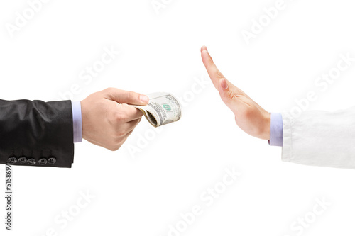 Photo: Man giving bribe to a doctor refusing the money Man giving bribe to a doctor refusing the money