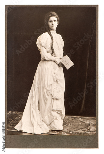 Photo: young woman in vintage dress posing with bible book young woman in vintage dress posing with bible book