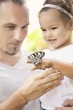 Dad and daughter are looking a butterfly