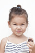 Photo: Asian little girl eating chocolate Asian little girl eating chocolate