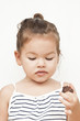 Photo: Asian little girl eating chocolate Asian little girl eating chocolate