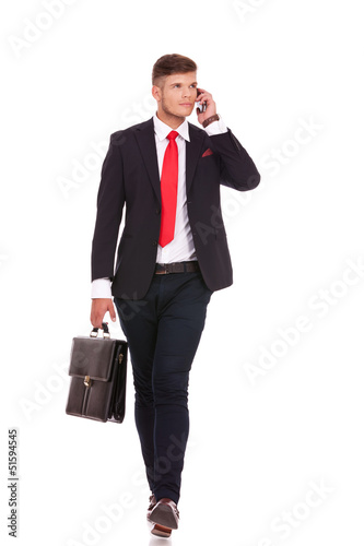 Photo: business man on phone walks business man on phone walks
