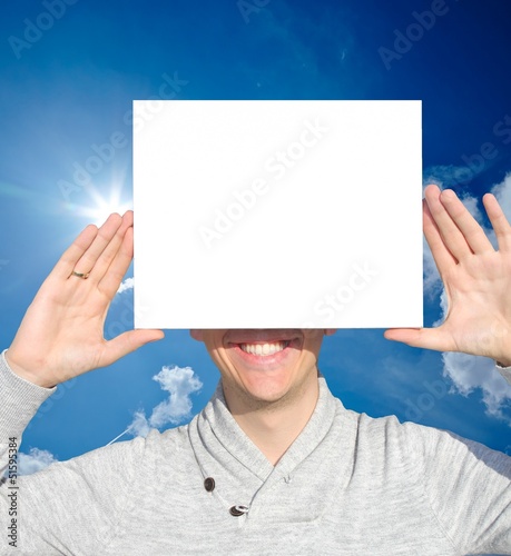 Photo: Mann mit Schild vor blauem Himmel Mann mit Schild vor blauem Himmel