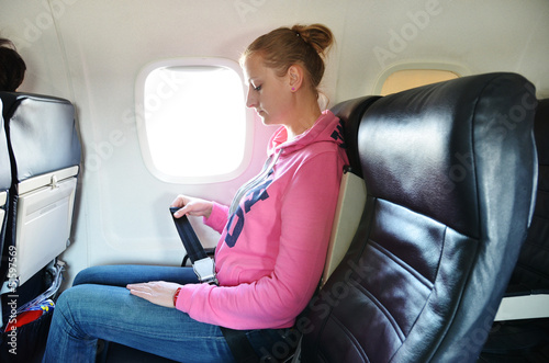 Photo: Girl fastening her seat belt Girl fastening her seat belt