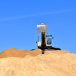 new yellow excavator working on sand dunes