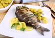 Grilled fish with potatoes, sauce and lemon