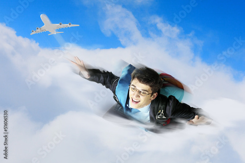 Photo: Young businessman flying with parachute on back Young businessman flying with parachute on back