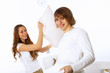 Young couple fighting with pillows