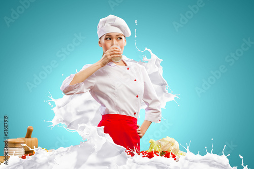 Photo: Asian female cook against milk splashes Asian female cook against milk splashes