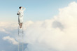 Businesswoman standing on ladder